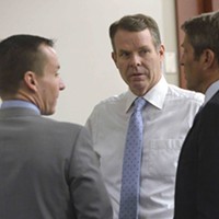 Cara Tangaro (left), Brad Anderson (center) and Scott Williams (right) surround their client, John Swallow.