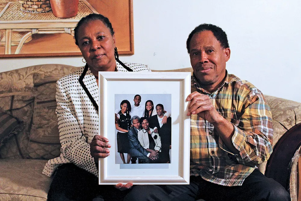 Marie Micheline and Jospeh Ernst Montfleury hold up a family portrait taken during happier times. - ENRIQUE LIMÓN