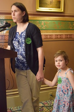 Mia Hockett, a Burlington doctor and mother, talks Tuesday at the Statehouse about the need for vaccinations. Her 4-year-old daughter, Merin, has leukemia, which compromises her immune system. - TERRI HALLENBECK