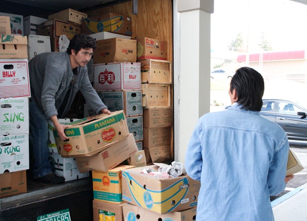 Thanh Pham (left) unloads produce from his truck