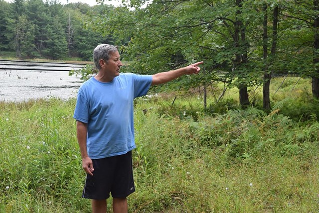 Former Lt. Gov. Brian Dubie points to the location of proposed wind turbines on land behind his house in Fairfield on the Swanton town line.