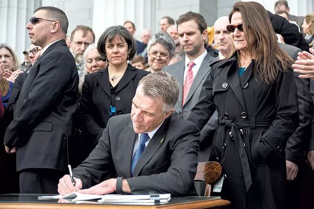 Gov. Phil Scott signing one of three gun bills in April - JOSH KUCKENS