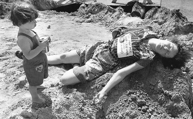 Robin Lloyd with son Jesse at a "die-in" during a renovation of Church Street. Her sign reads, "We are all Hibakusha" (Hiroshima bomb survivors). - COURTESY OF JESSE LLOYD GUMA