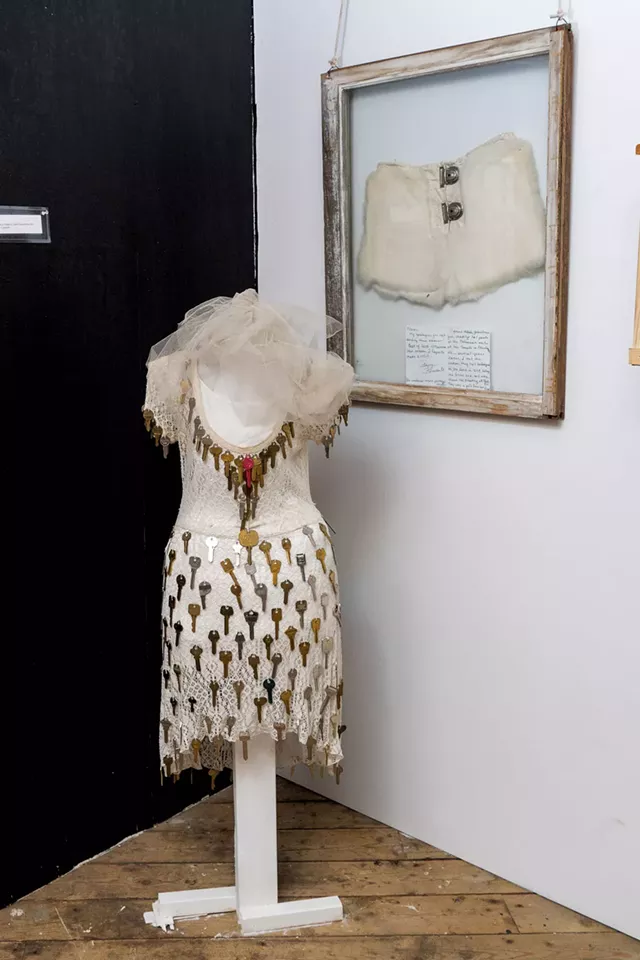 Installation with pair of white leather fetish pants, complete with a locking fly, on the wall - DON WHIPPLE
