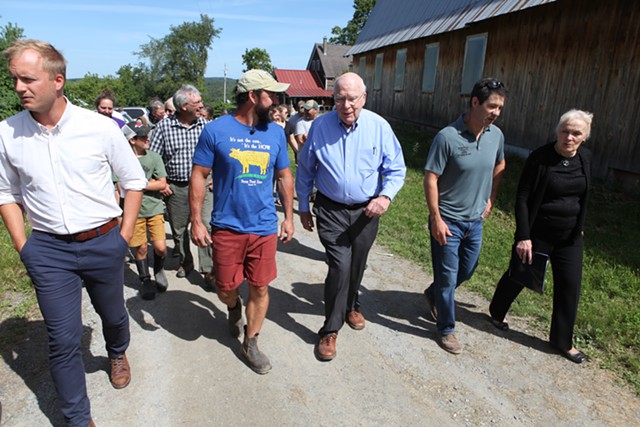 Stony Pond Farm owner Tyler Webb leads Vermont Sen. Patrick Leahy on a tour of the 300-acre dairy farm in Fairfield. - KEVIN MCCALLUM