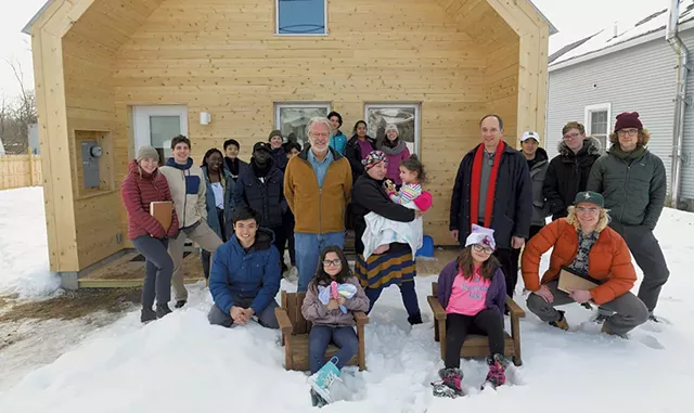 Steve Ingram (center left) and Middlebury College professor John McLeod (center right) with homeowner Dora Rivera (center), her children and McLeod's class - JON OLENDER