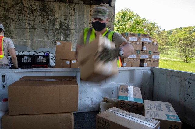 A guardsman loading food into a pickup truck Tuesday in Burlington - JAMES BUCK