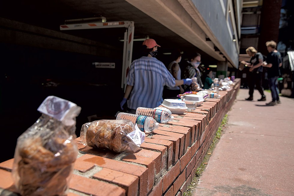 A Food Not Bombs volunteer sorting through donations - JAMES BUCK