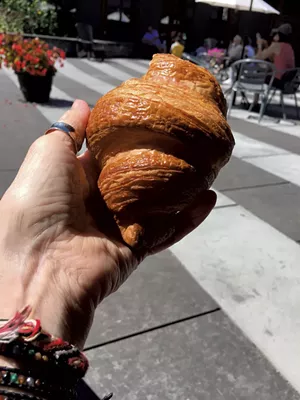 Dining on a croissant at King Arthur Baking's outdoor plaza - PAMELA POLSTON ©️ SEVEN DAYS