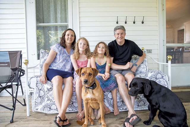 Erik and Kelly Johnson with their daugters, Greta and Cecilia, and the family dogs on the farmhouse porch - JAMES BUCK