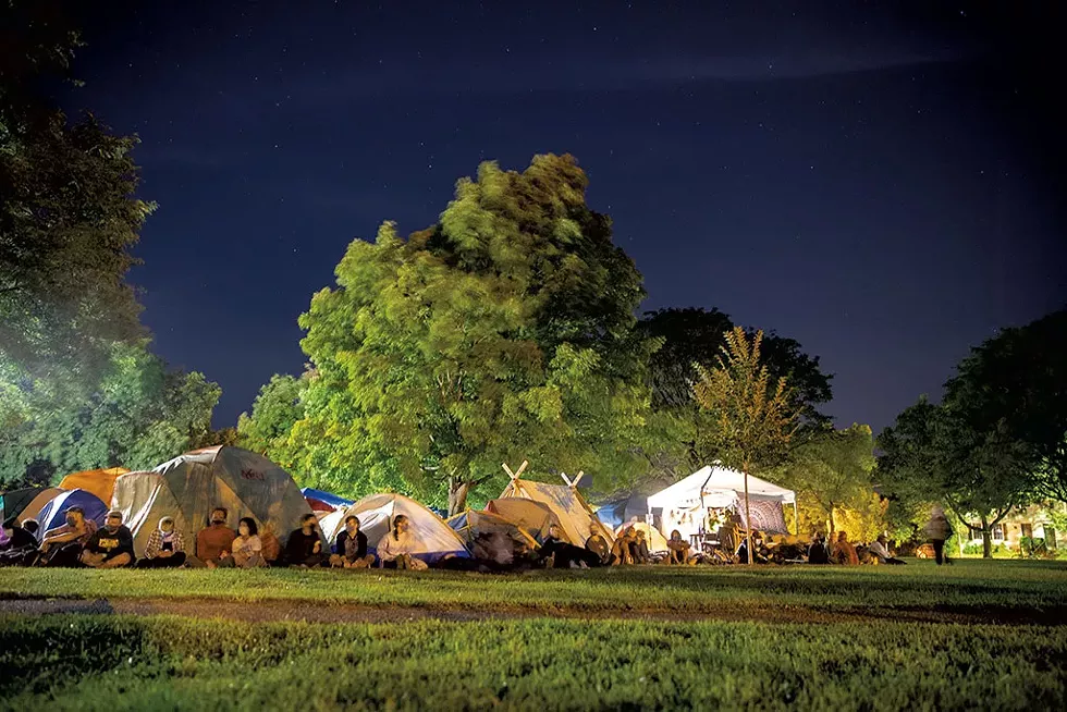 Protesters gathering around the tents in anticipation of potential police presence - JAMES BUCK