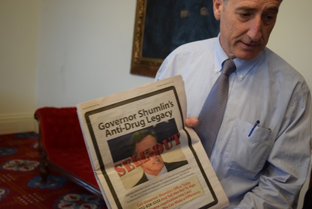 Thursday morning at the Statehouse, Gov. Peter Shumlin shows off an advertisement attacking him. - TERRI HALLENBECK