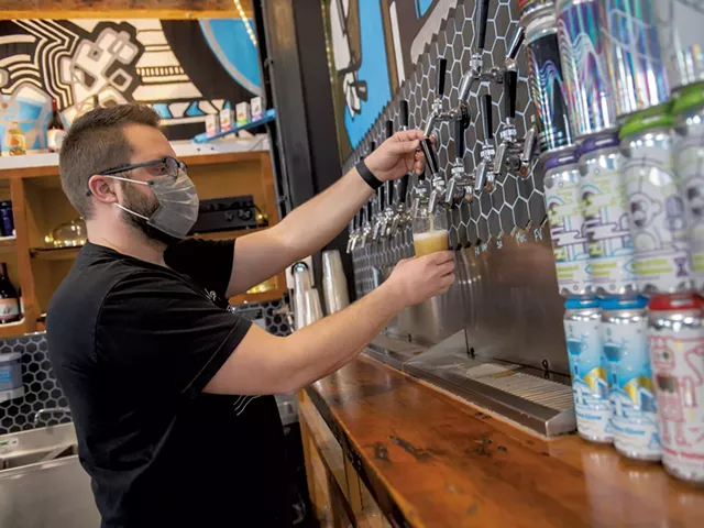 Joe Lemnah filling a glass with Uncanny Valley, a New England IPA - DARIA BISHOP
