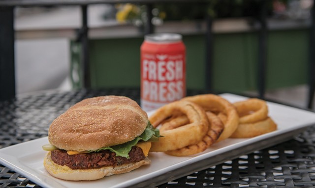 A plant-based burger and onion rings served with a Fresh Press apple cider at Nourish - DARIA BISHOP
