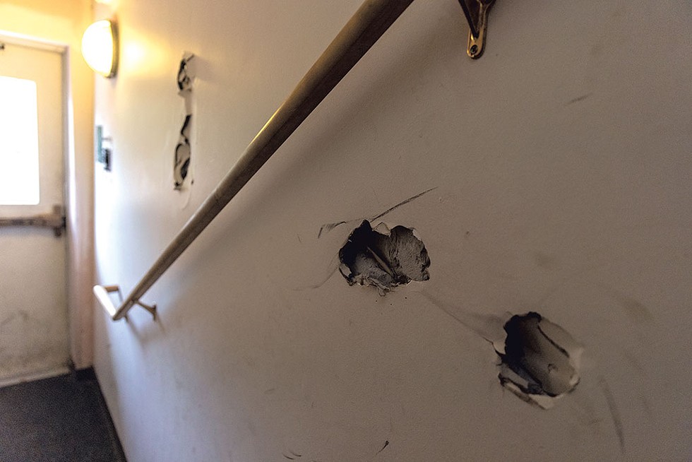 Holes in the wall in the hallway of Monarch Apartments in Essex - JAMES BUCK