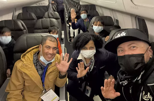 James Buck (right) with an airline employee and Afghan refugees - JAMES BUCK