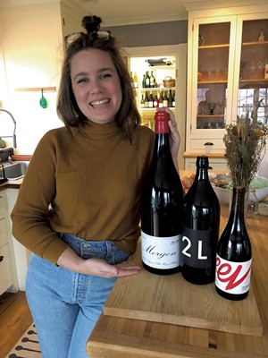 Jordan Barry with a three-liter bottle of Domaine Marcel Lapierre Morgon from Wilder Wines (other bottles for scale) - JORDAN BARRY ©️ SEVEN DAYS