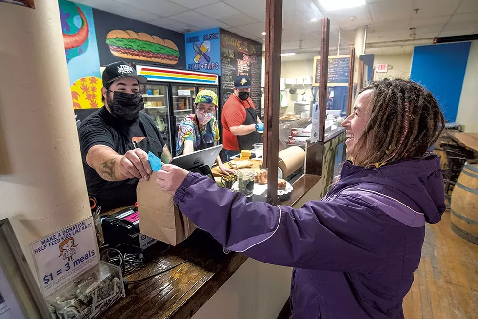 Seleste Weeks picking up food from Stefano Coppola at the Morse Block Deli in Barre - JEB WALLACE-BRODEUR