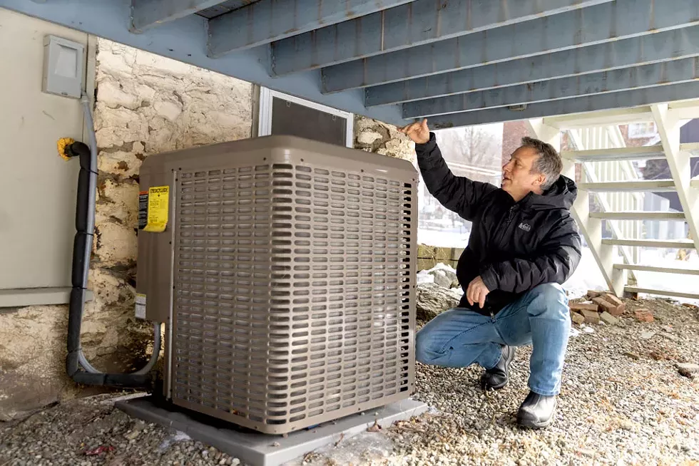 Marin shows off the heat pump under his deck. - JAMES BUCK