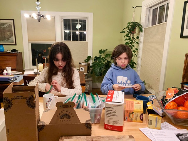 Lila and her sister putting COVID-19 kits together at home - COURTESY