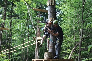 Gabe Tharp helps son Wylie onto the zip line