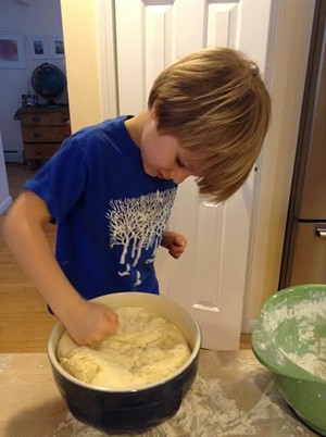 Theo happily punching the dough.