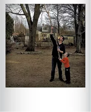 Chris Bourdeau helping his son Phin get a boomerang out of a tree in their backyard earlier this spring. Submitted by Kele Bourdeau, Burlington