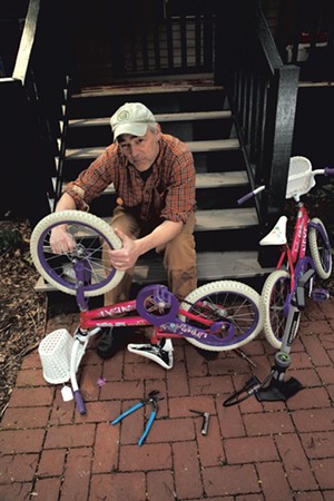 Erik Esckilsen fixes his twin daughters' bikes - MATTHEW THORSEN