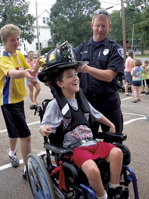 Ben tries on a firefighter&rsquo;s hat - COURTESY OF DEBBIE LAMDEN