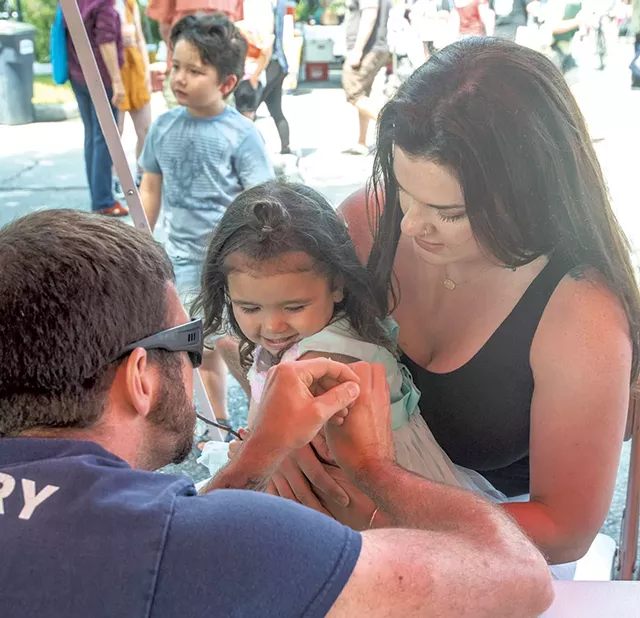 Rachel Gwinn holding her daughter Estelle, 2, as she receives a COVID-19 vaccine - JEB WALLACE-BRODEUR