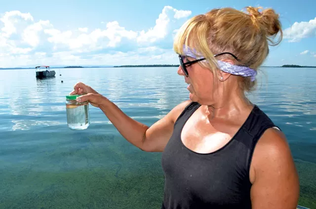 Cathy Hickory with a sample of lake water - MOLLY WALSH