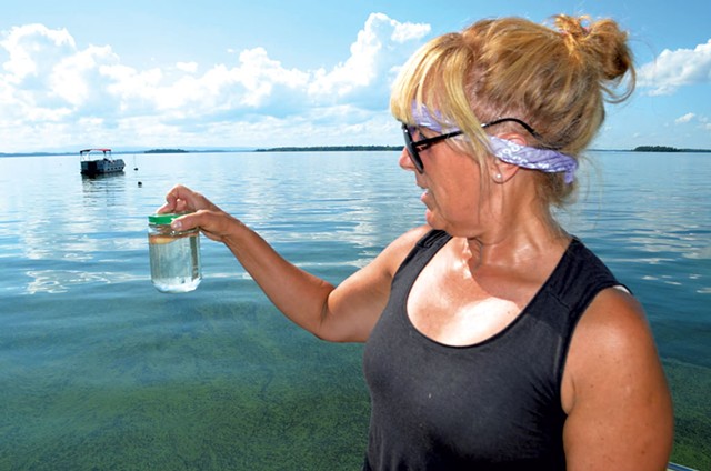 Cathy Hickory with a sample of lake water - MOLLY WALSH