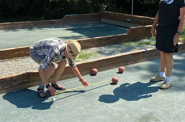 Ashley Watson measuring a throw's distance from the pallino - ERIK ESCKILSEN