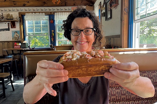 Paula Routly holding a lobster roll at Cajun's Snack Bar in Lowell - COURTESY