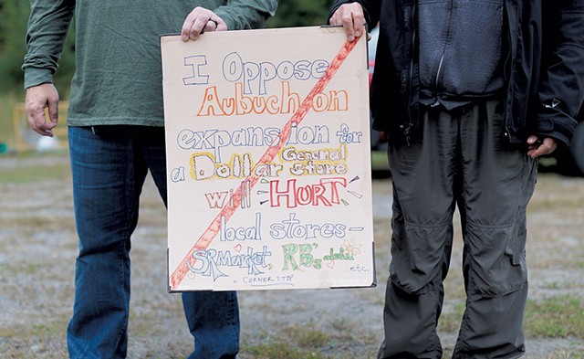Community members holding a sign opposing Dollar General - BEN DEFLORIO