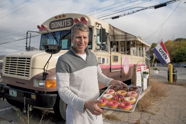 Andrew Machanic with fresh doughnuts by his Sweet Wheels Donuts bus - DARIA BISHOP