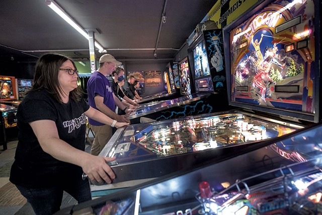 Allison Havens and others playing pinball between tournament rounds - DARIA BISHOP