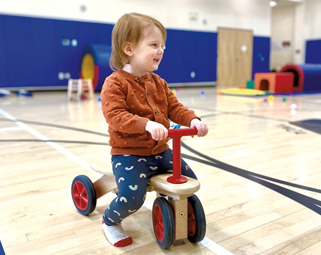 Riding on a toddler bike in the gymnasium during family recreation time at the YMCA. - JULIE GARWOOD
