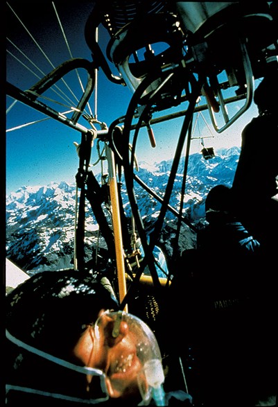 Jan Reynolds in an oxygen mask with a hanging camera, flying a hot-air balloon over Mount Everest - COURTESY OF JAN REYNOLDS
