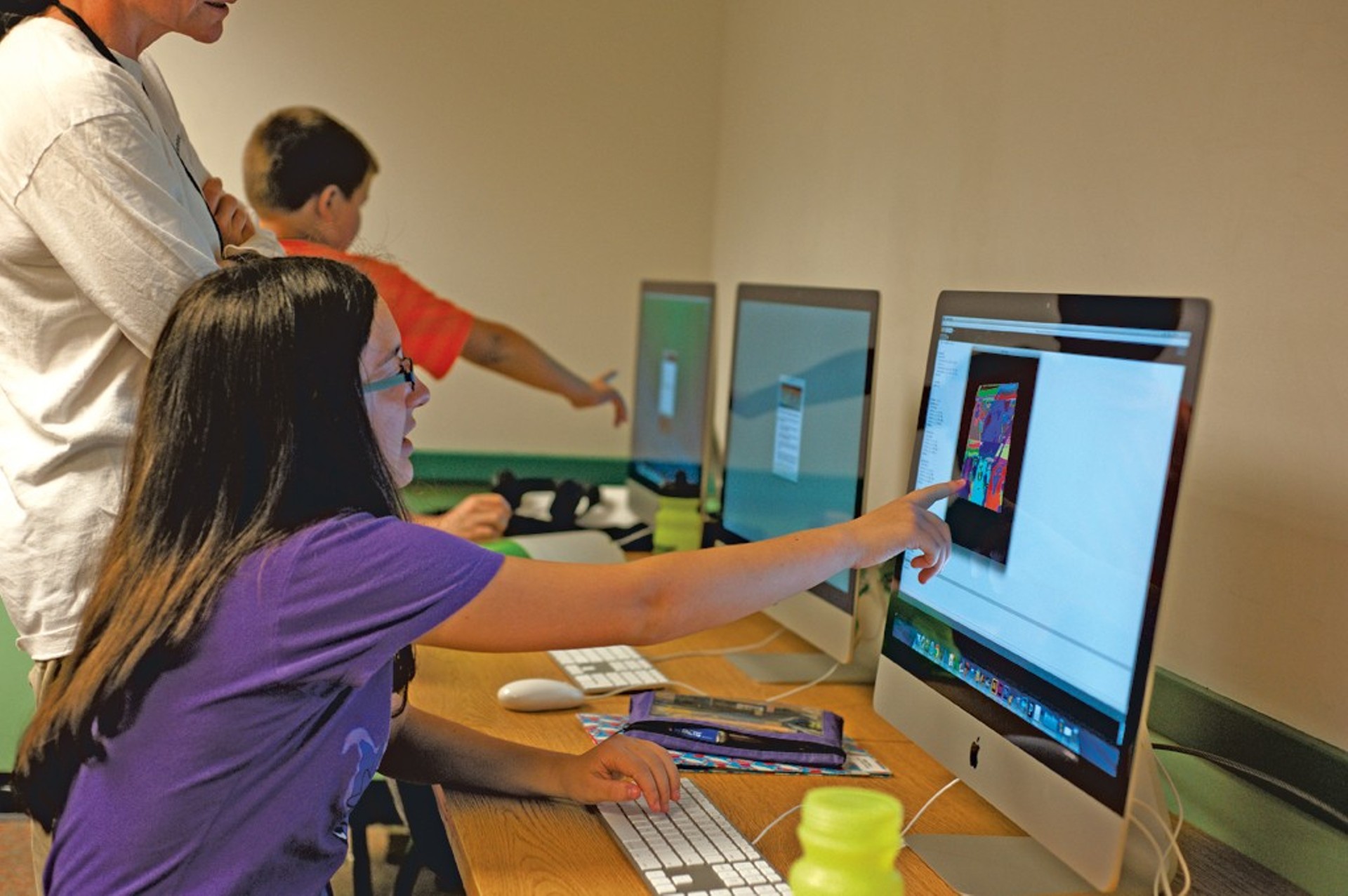Young programmers work on digital art at Code Camp.
