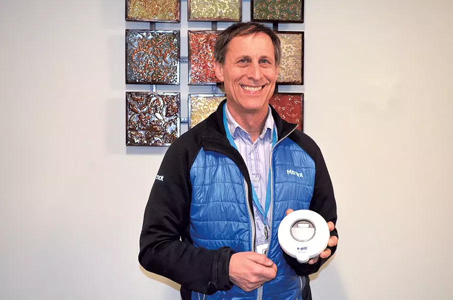 Dr. John Brooklyn holding an electronic pill dispenser - ALICIA FREESE
