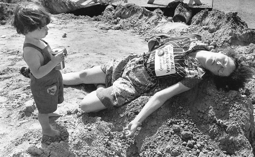 Robin Lloyd with son Jesse at a "die-in" during a renovation of Church Street. Her sign reads, "We are all Hibakusha" (Hiroshima bomb survivors). - COURTESY OF JESSE LLOYD GUMA
