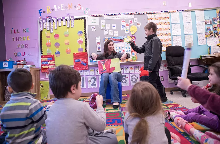 Stephanie Carvey telling a story to kids at Rekaroo's Childcare in Rutland, Vt. - CALEB KENNA