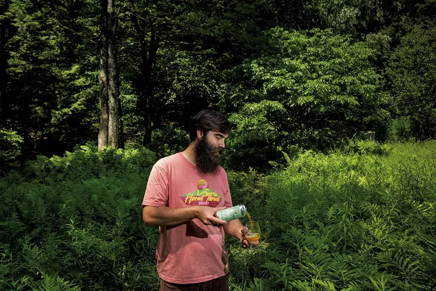 Christophe Gagné pouring a glass of Windham Flora while standing in the wilderness behind Hermit Thrush Cellars - ZACHARY P. STEPHENS