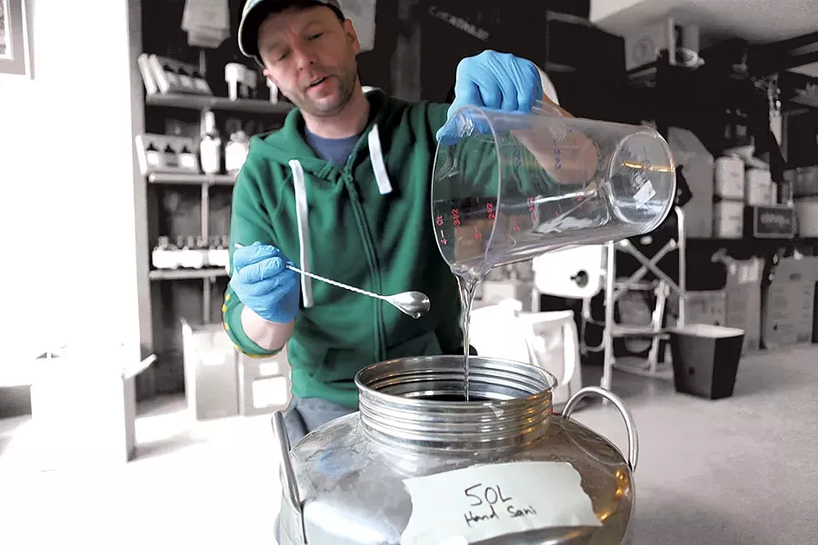 Alex Hilton adding glycerine to a batch of hand sanitizerRay Merola - KEVIN MCCALLUM