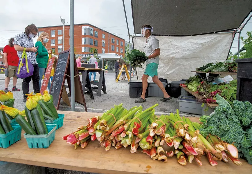 Robert Linck, from Fusda Farm, bringing mustard greens to a customer at the Capital City Farmers Market - JEB WALLACE-BRODEUR