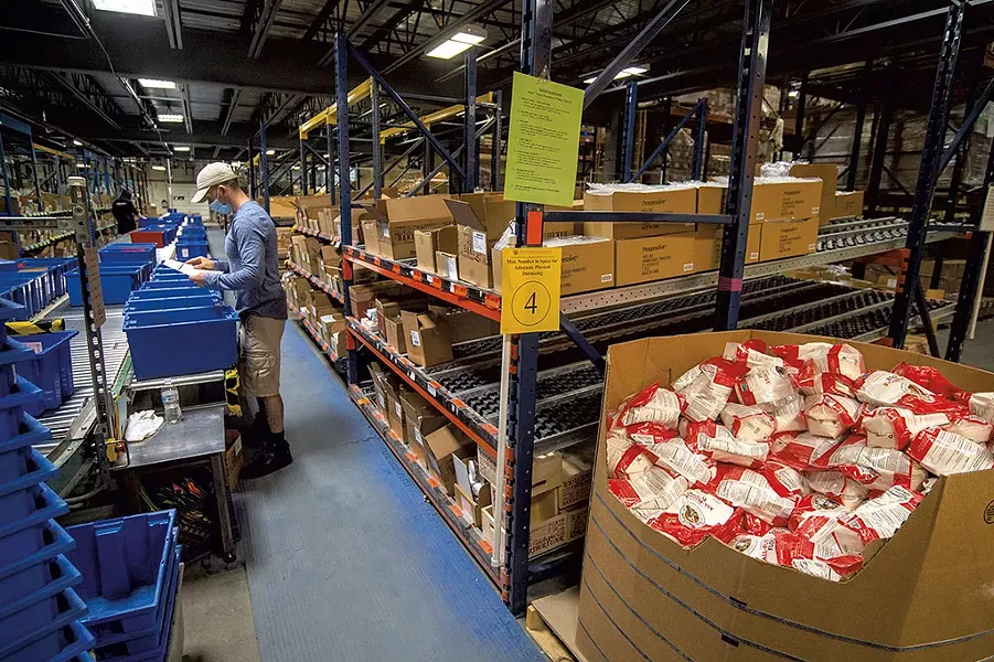 Justin Severance filling mail orders at the fulfillment center - JEB WALLACE-BRODEUR