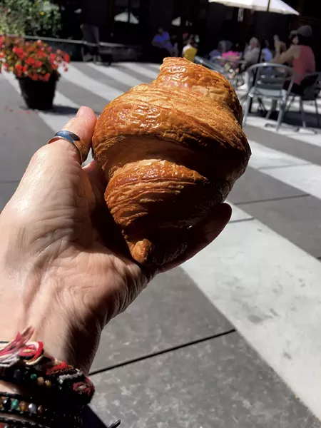 Dining on a croissant at King Arthur Baking's outdoor plaza - PAMELA POLSTON ©️ SEVEN DAYS