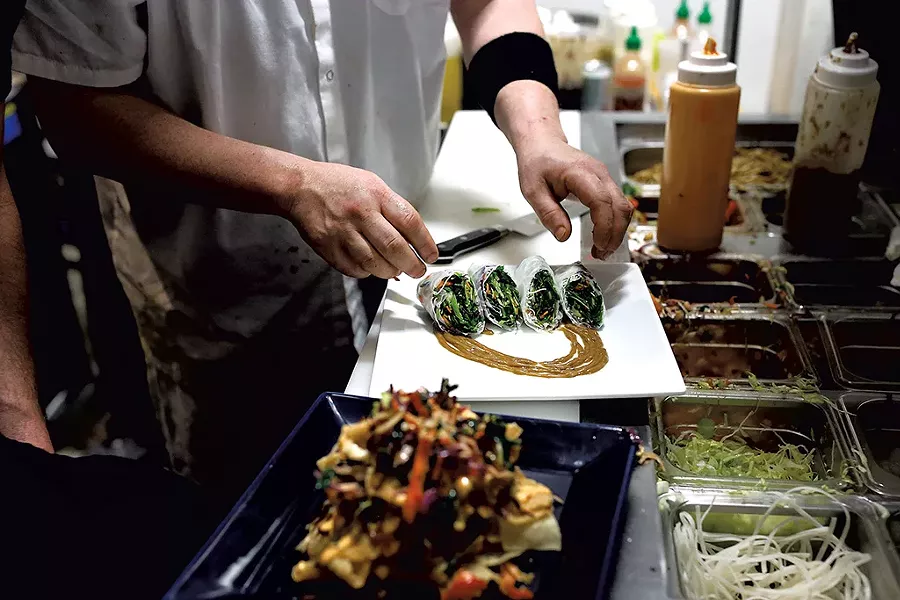 John Hessler putting the finishing touches on some spring rolls - SARAH PRIESTAP