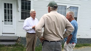 David Hall, left, chats with Bill Emmons, center, after meeting with members of the Two Rivers-Ottauquechee Regional Commission.